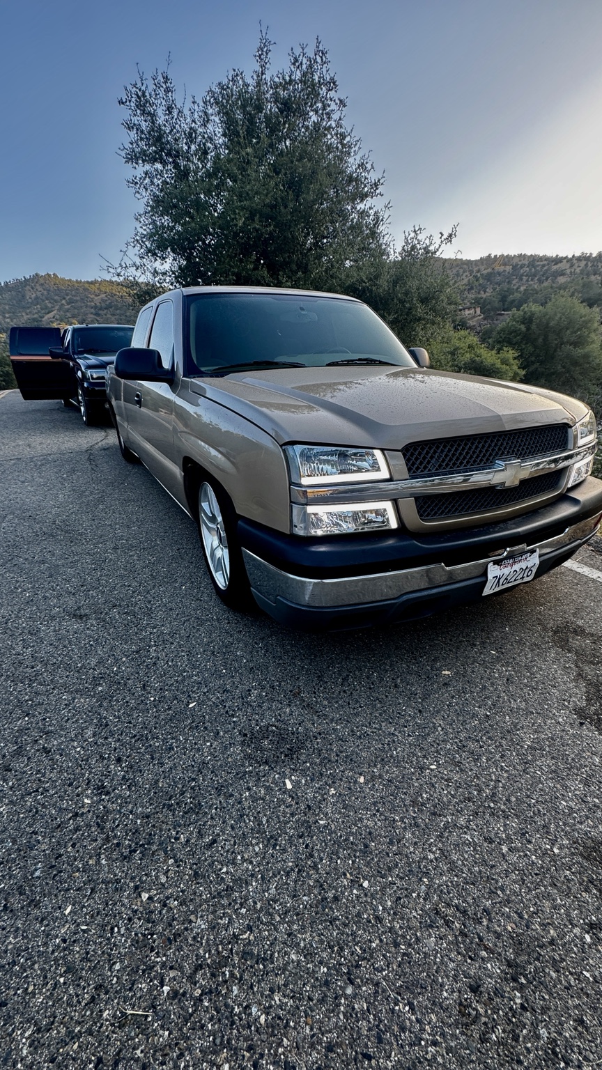 Silver Chevrolet Silverado parked on a scenic road in daylight